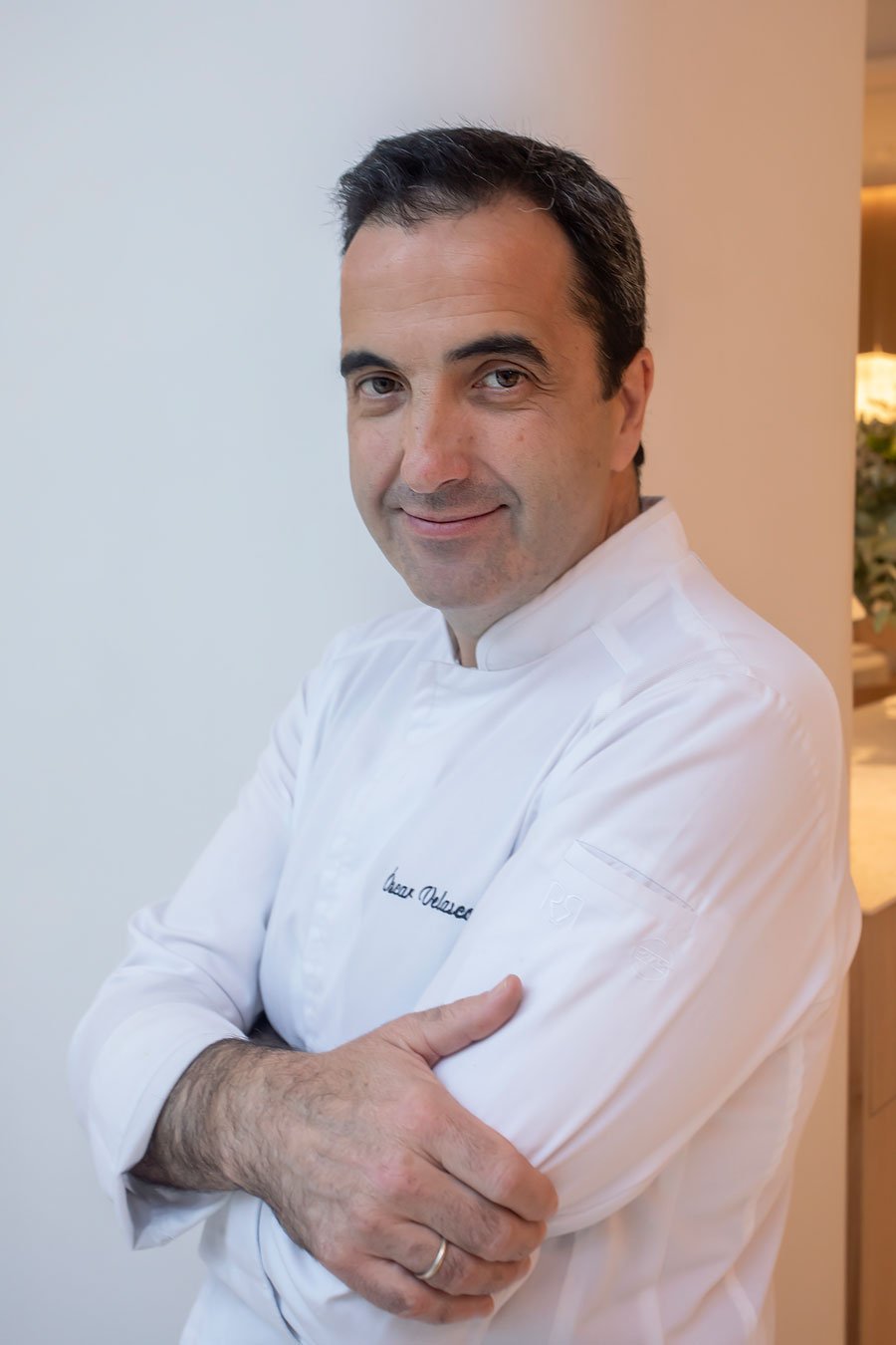 Retrato de Óscar Velasco, chaqueta de chef blanca.