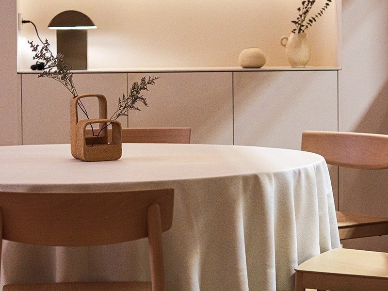 Mesa redonda vestida con mantel blanco, preparada para el menú degustación.